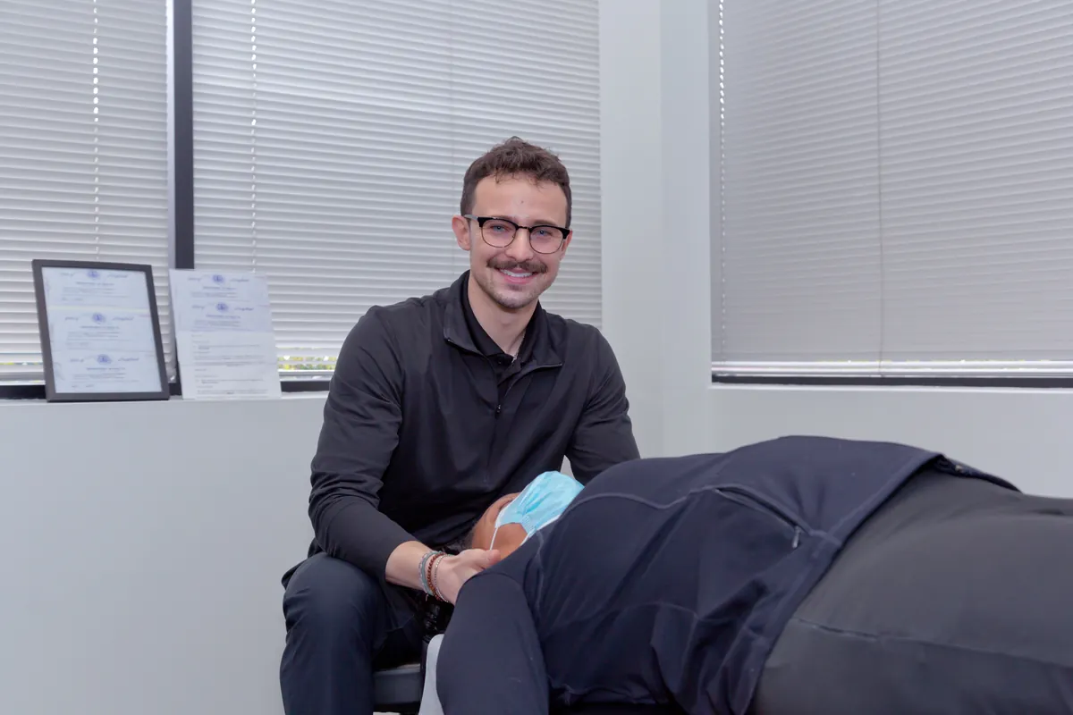 Dr. Connor Reed treating a patient lying face down on a chiropractic table